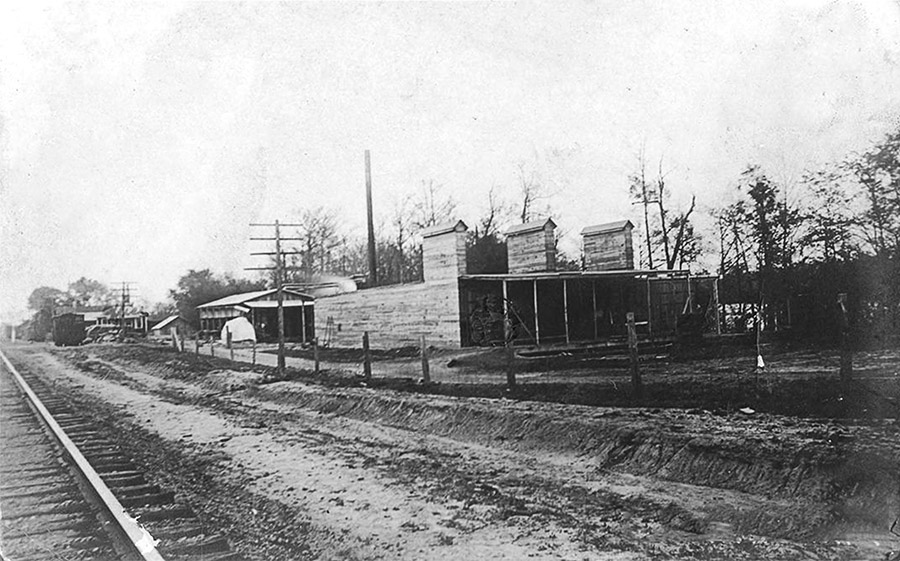 Lumber storage buildings with railroad tracks in the foreground