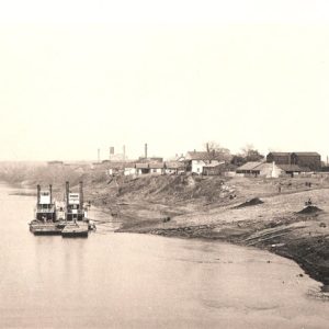 Pair of steamboats socked on river with town buildings in the background