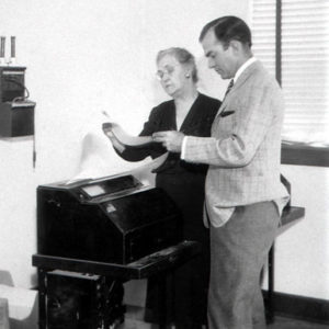 White man and his mother using a teletype machine