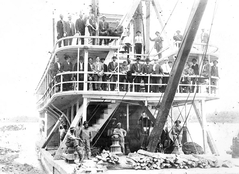 People standing on deck of steamboat