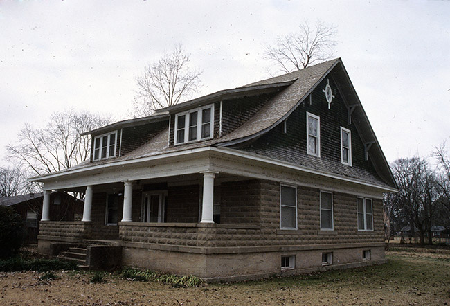 Two-story brown house with covered porch