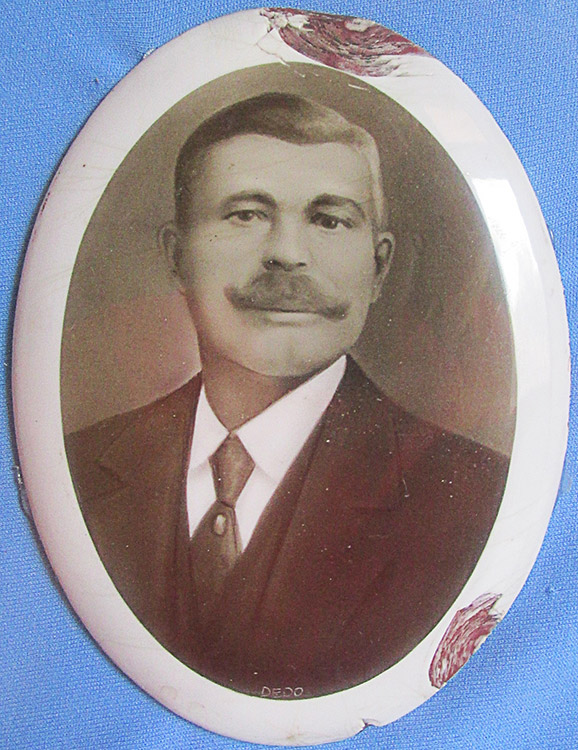 White man with curly mustache in suit and tie