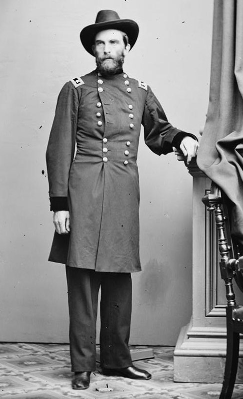 White man with beard standing in military uniform and hat