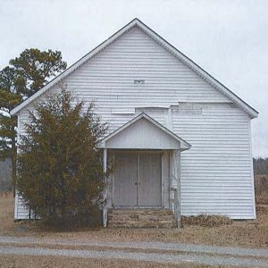 Front view of single-story building with wood siding and covered entrance