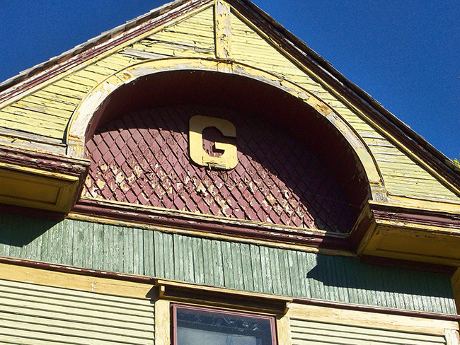 Close-up of letter G on multistory house with red green and yellow paint