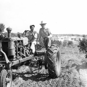 Two men riding on tractor