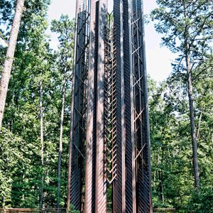 Tower with copper clad steel frame and columns in wooded area