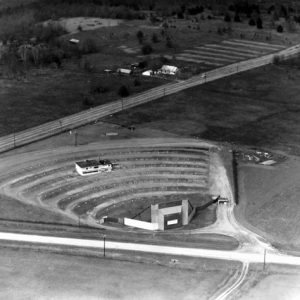 Aerial view of drive-in theater and street with house in the background