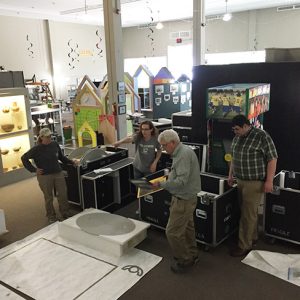 Two white men and two white women unpacking displays in museum