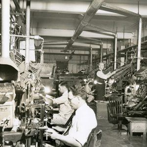 White men working with machinery in composition room