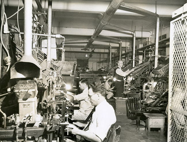 White men working with machinery in composition room