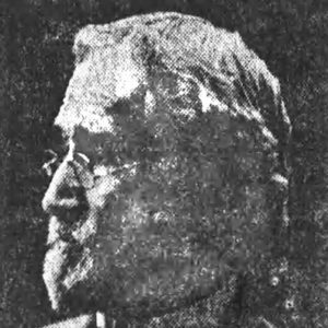 Profile view of old white man with glasses in suit and bow tie
