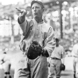 White man in uniform with glove throwing a pitch