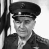 Older white man in military uniform with hat and American flag
