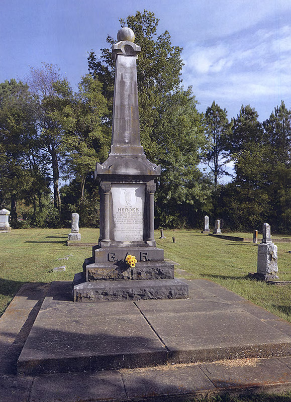 Tall weathered stone monument in cemetery