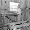 White man with hat standing in wood shop