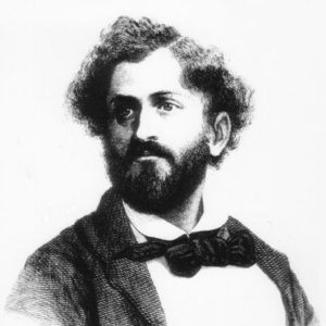 White man with curly hair and beard in suit and bow tie