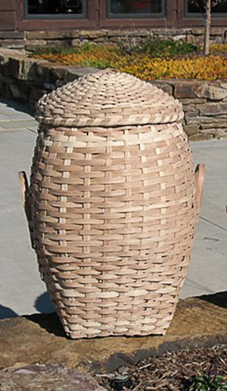 Large basket with lid on brick wall