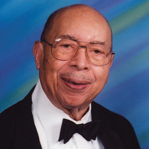 Older African-American man with glasses smiling in tuxedo