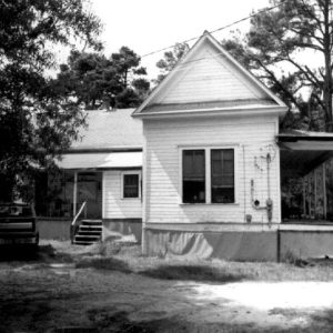 Side view of single-story house with truck parked at back porch
