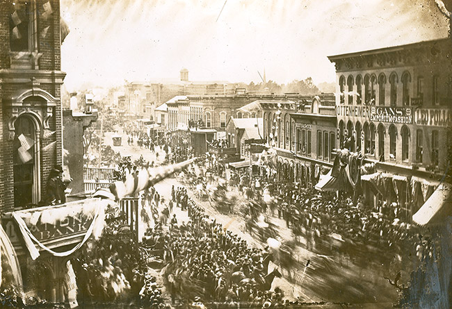 Parade with crowd and horses on crowded city street