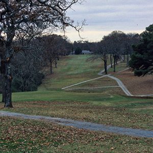 Golf course with overcast skies trees and walking paths