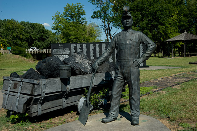 Statue of miner with mine cart loaded with coal