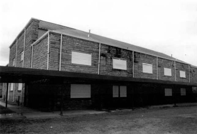 Rear of brick gymnasium building with covered walkway