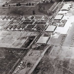 Aerial view of rows of buildings opposite a field of parked airplanes
