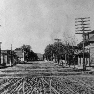 Storefronts and power lines on dirt road