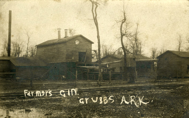 Gin building and outbuildings with bare trees and railroad