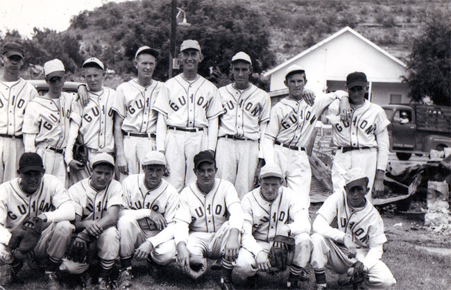 Group of white men posing in "Guion" uniforms with caps and mitts