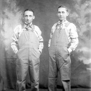 Two white men wearing overalls
