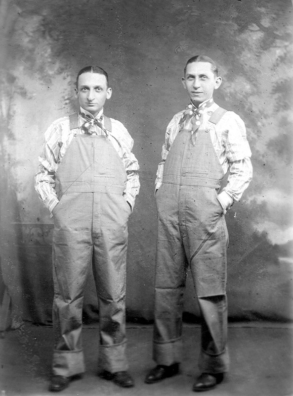 Two white men wearing overalls