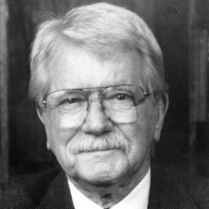 Old white man with glasses and mustache in suit and tie