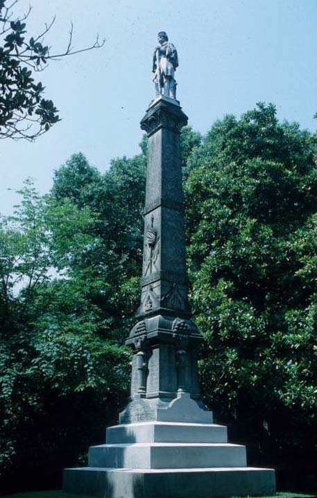 Soldier on top of obelisk shaped monument with pedestal