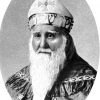 White man with long beard in bishop's robes and miter with cross