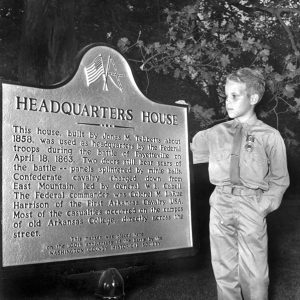 White boy standing next to commemorative plaque