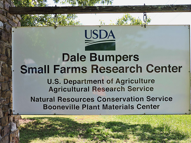 Sign saying "USDA Dale Bumpers Small Farms Research Center" hanging on brick column