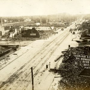 Destroyed buildings on city street signed  "Looking south on Ouachita Ave after the fire September 5, 1913"