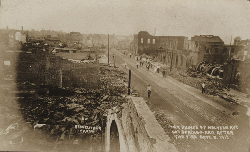 Destroyed buildings on city street with people milling about