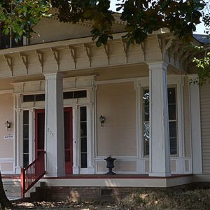 Close-up of porch with columns and red doors
