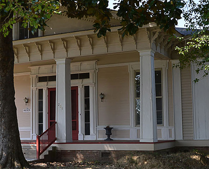 Close-up of porch with columns and red doors