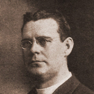 White man with glasses in suit with white collar