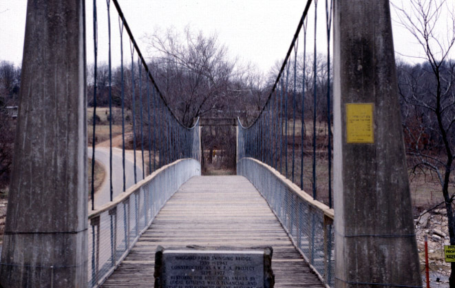 Looking down suspension foot bridge with plaque