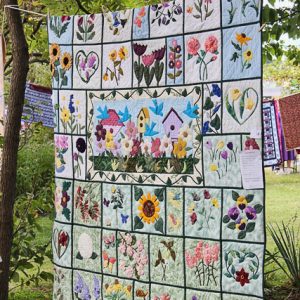 Large floral quilt hanging between two trees