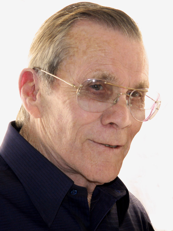 Old white man with glasses smiling in collared shirt