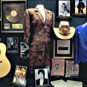Music memorabilia with guitar stage clothes and photographs in display case