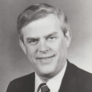 White man smiling in suit and tie