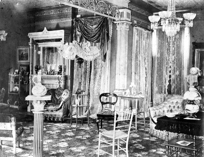 Ornate room with fireplace, wood furniture, and tiled ceiling